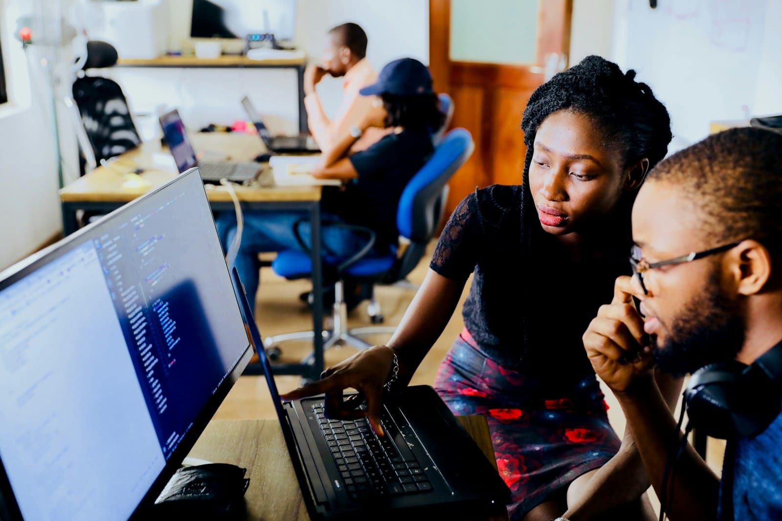 A software team working through code together in an open-plan office