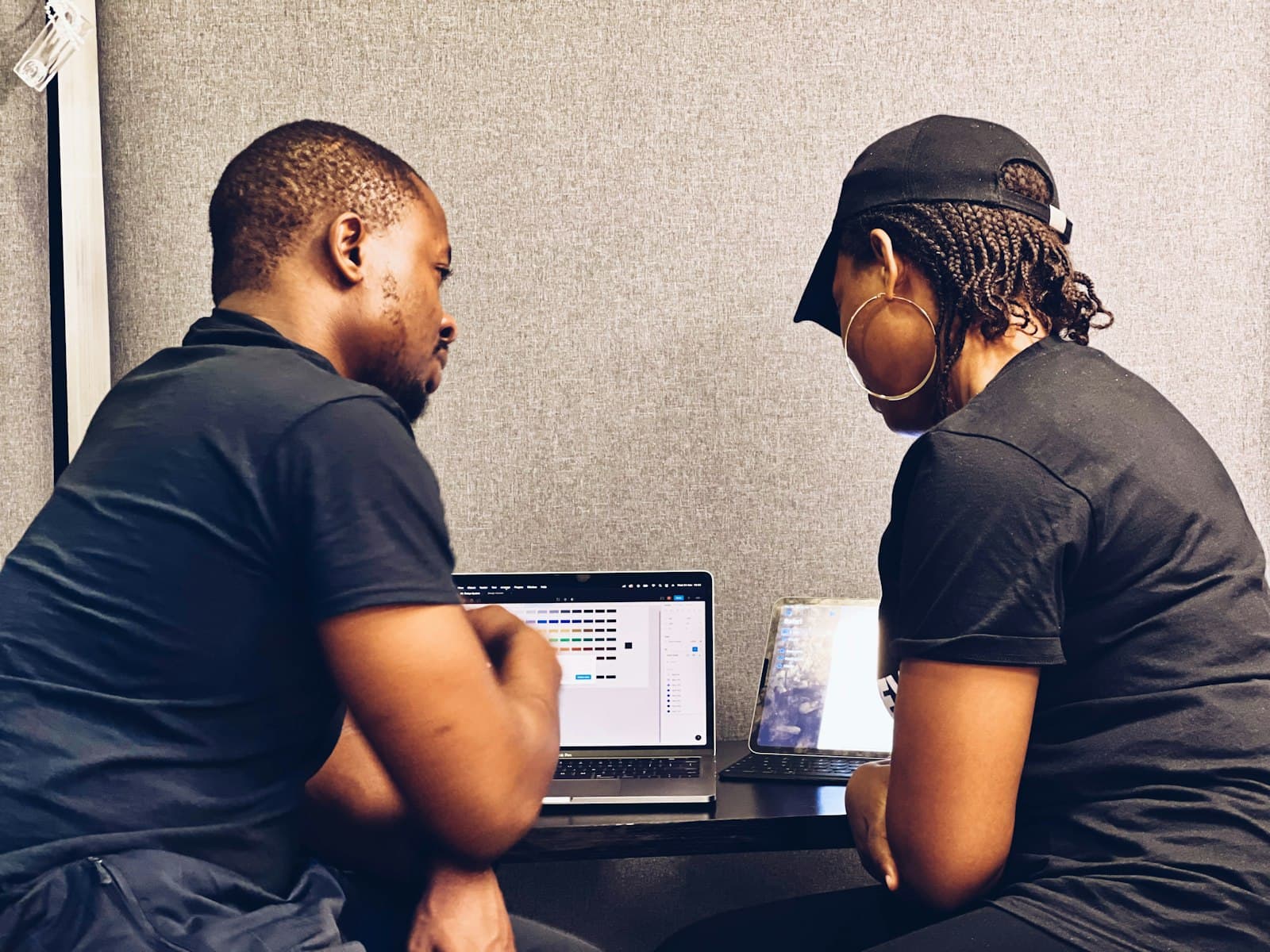 A supplier and a client going over documents together on a laptop